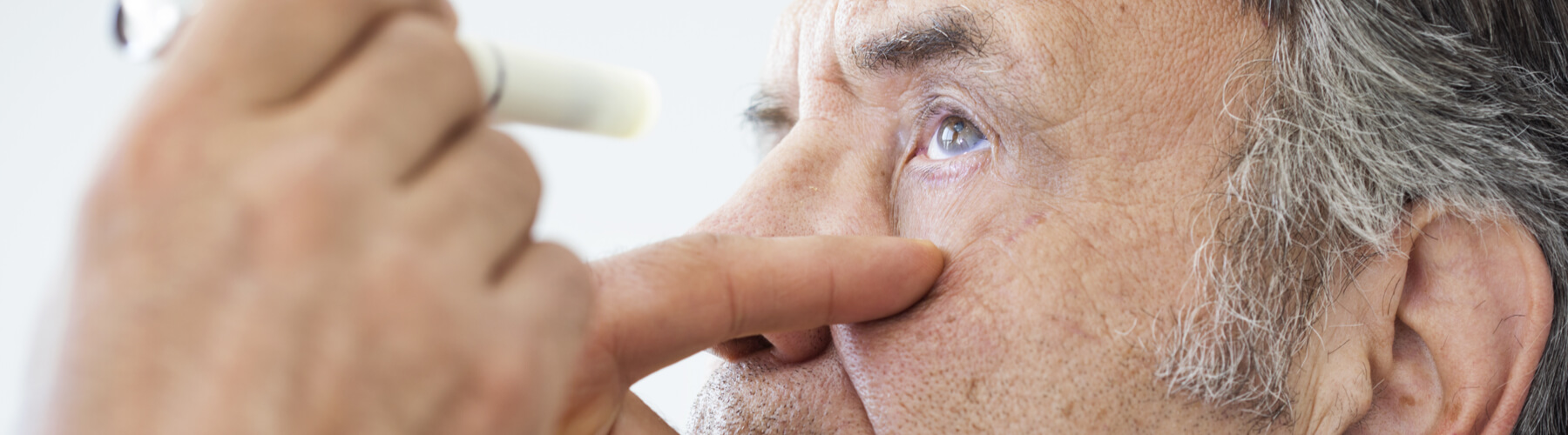 Elderly man examined by an ophthalmologist, hypertension or high blood pressure exam from eye doctor