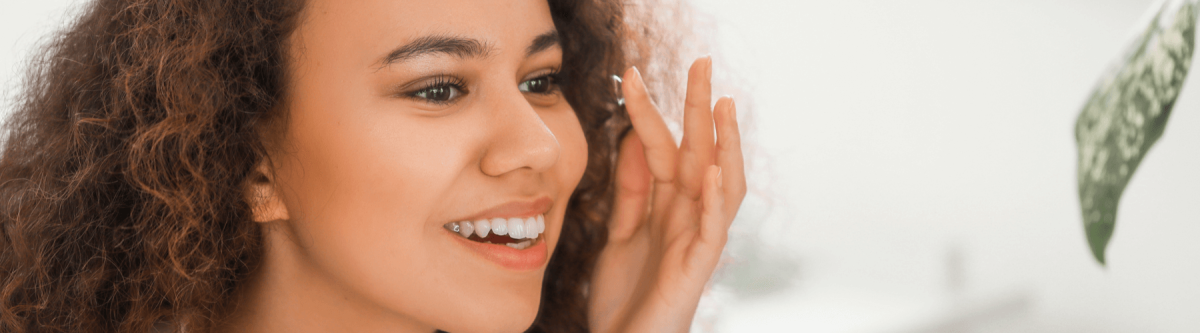 Young African-American woman putting in contact lenses at home, contact lenses to help relieve dry eye symptoms