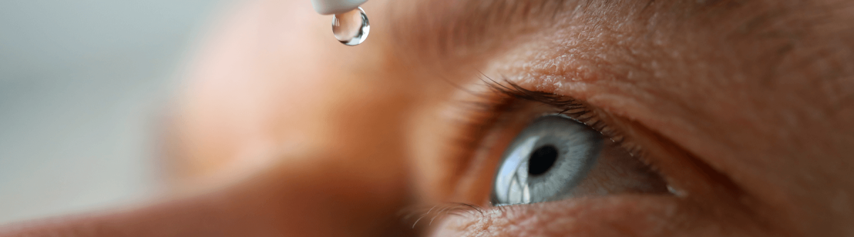 Man putting eye drops in eye