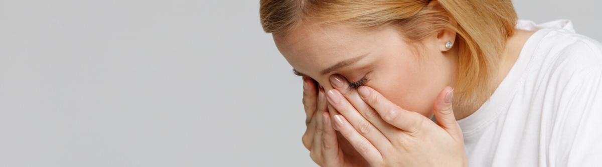 young blonde woman with her hands or fingers pressed against her eyes, dry eye syndrome concept, woman rubbing her dry eyes with hands