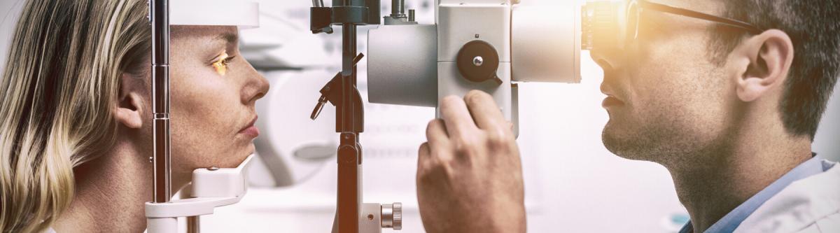 optometrist examining female patient on slit lamp in ophthalmology clinic